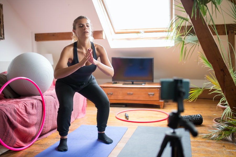 Woman recording while doing yoga