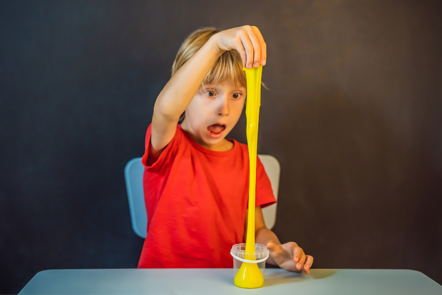 boy playing with yellow slime