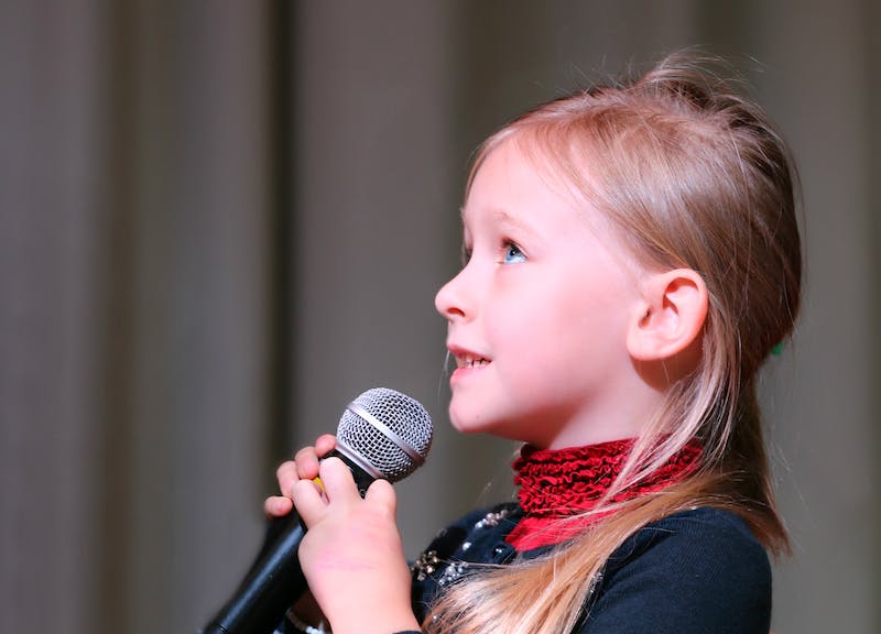 child singing with microphone