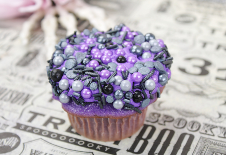 Purple cupcake with frosting and sprinkles