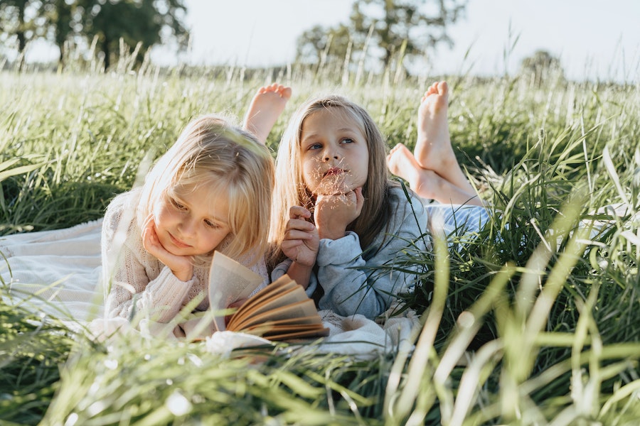 girls reading in the grass