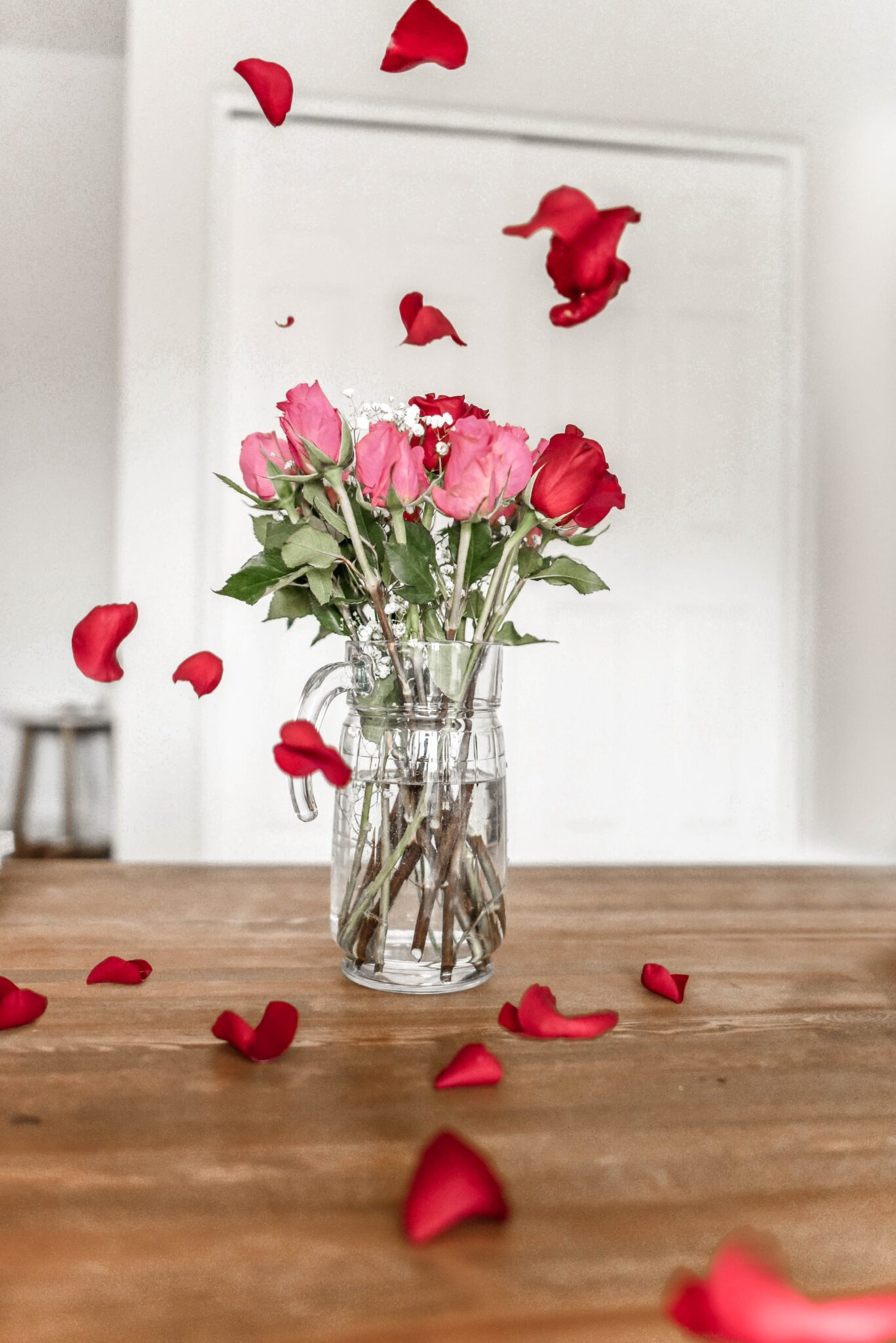roses in vase petals falling