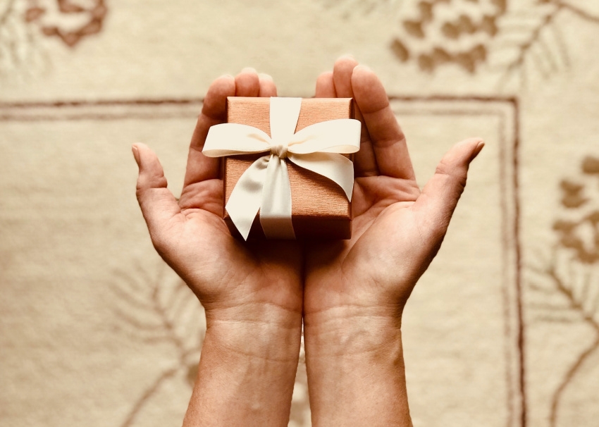 A small gift box in the palm of hands.