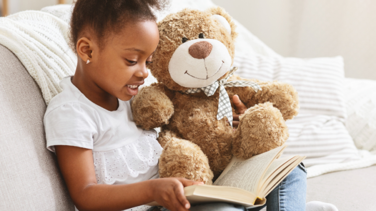 child reading with teddy bear