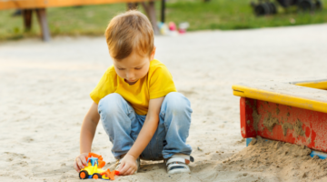child playing alone in sand