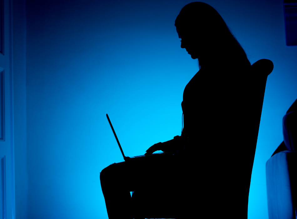 anonymous figure using laptop