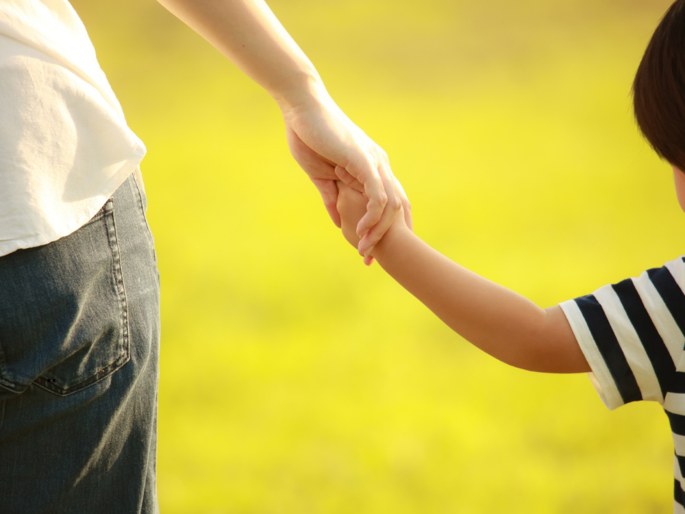 parent holding child's hand