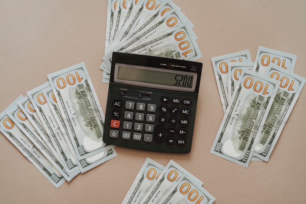 A calculator near dollar bills.