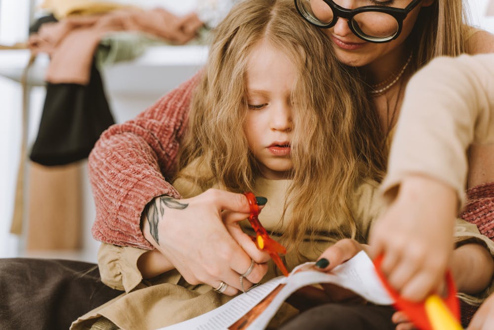A mother helping her daughter to craft.