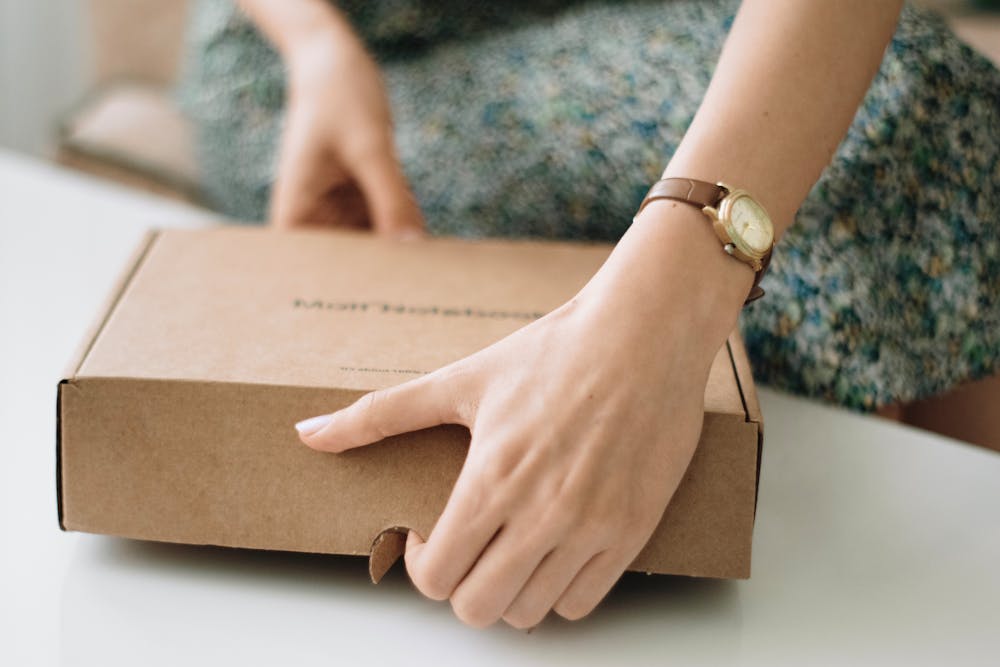 A woman opening an eco-friendly package at home.
