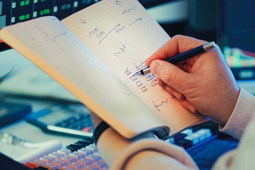 Person checking off information in a notebook.