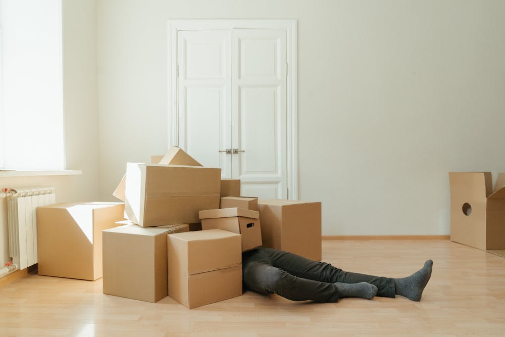 person laying under boxes