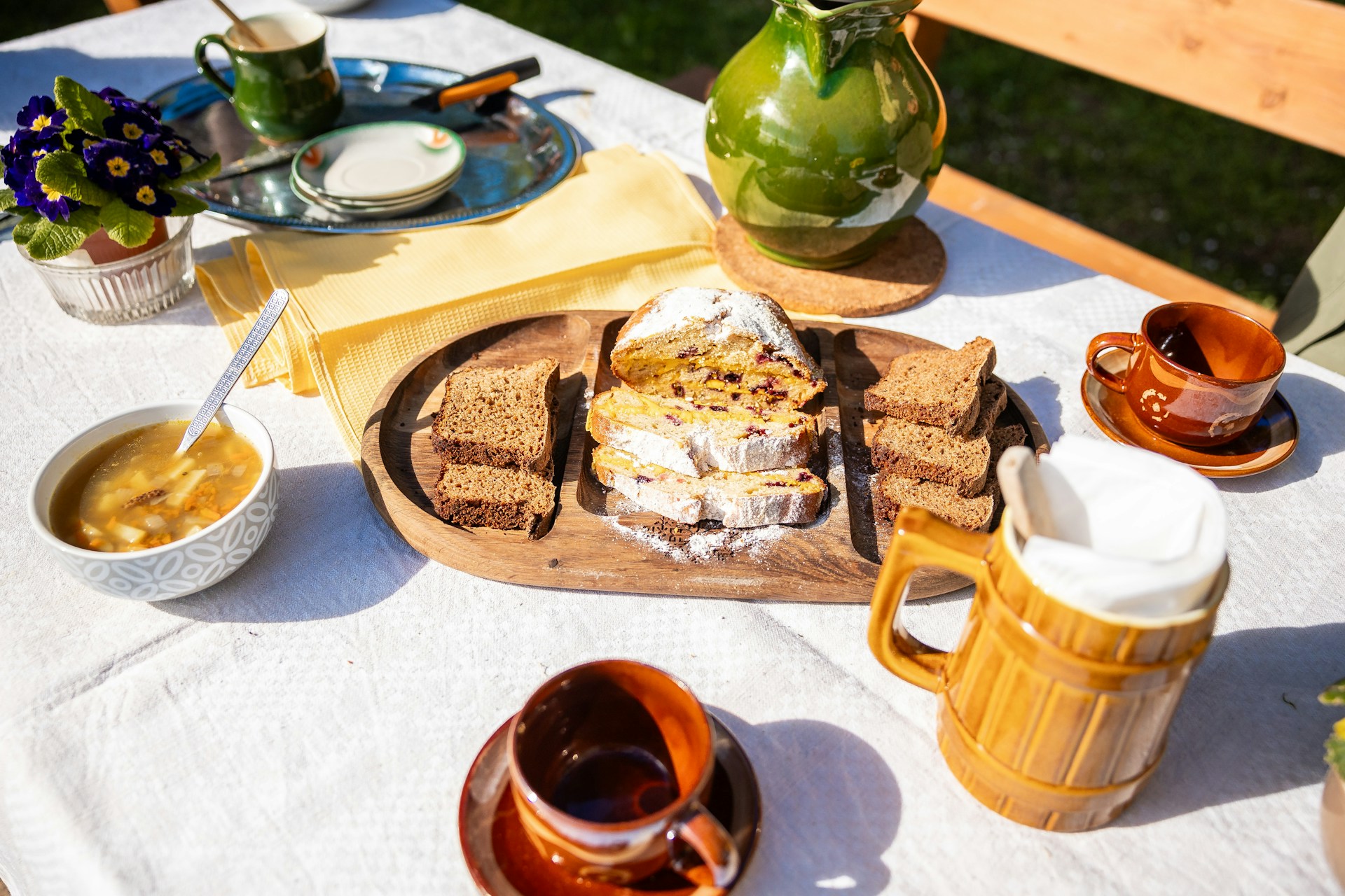 Smiling mom in a casual sundress at an outdoor brunch table with coffee