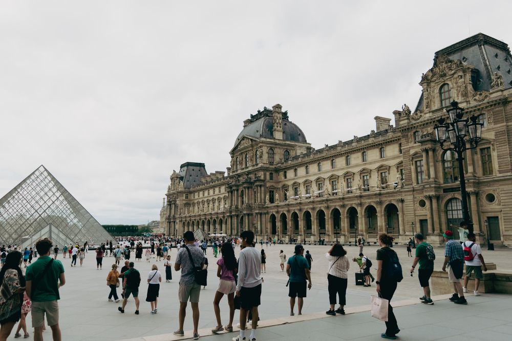 people walking around the louvre