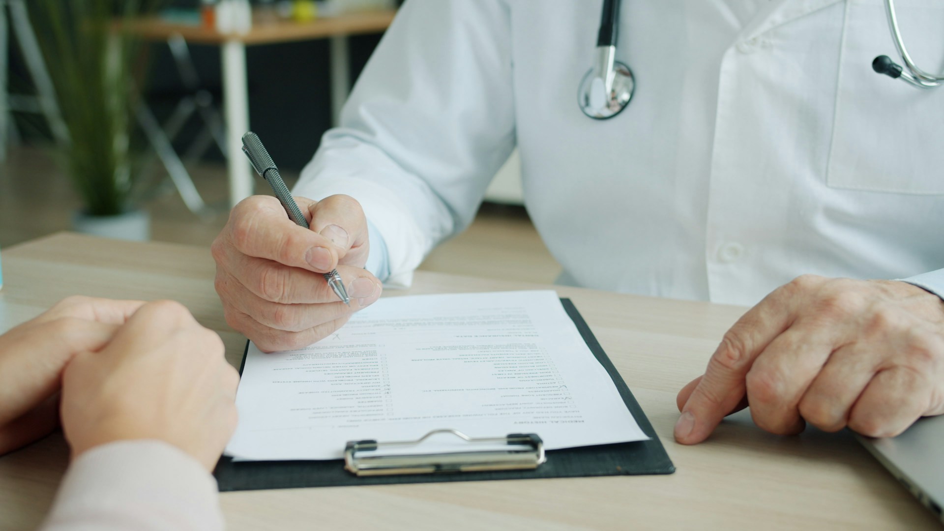 doctor writing on chart