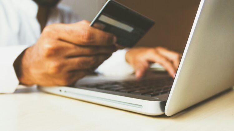 holding credit card using laptop