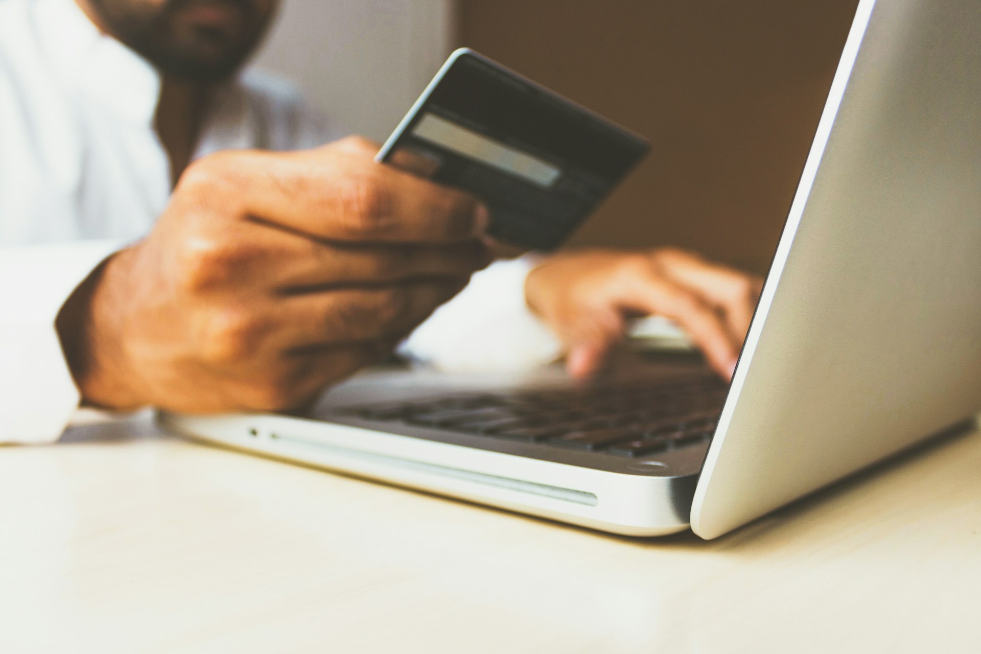 holding credit card using laptop
