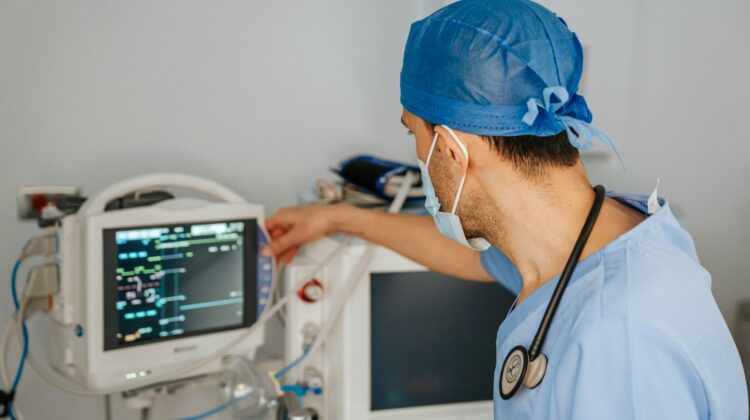 man in scrubs looking at monitor