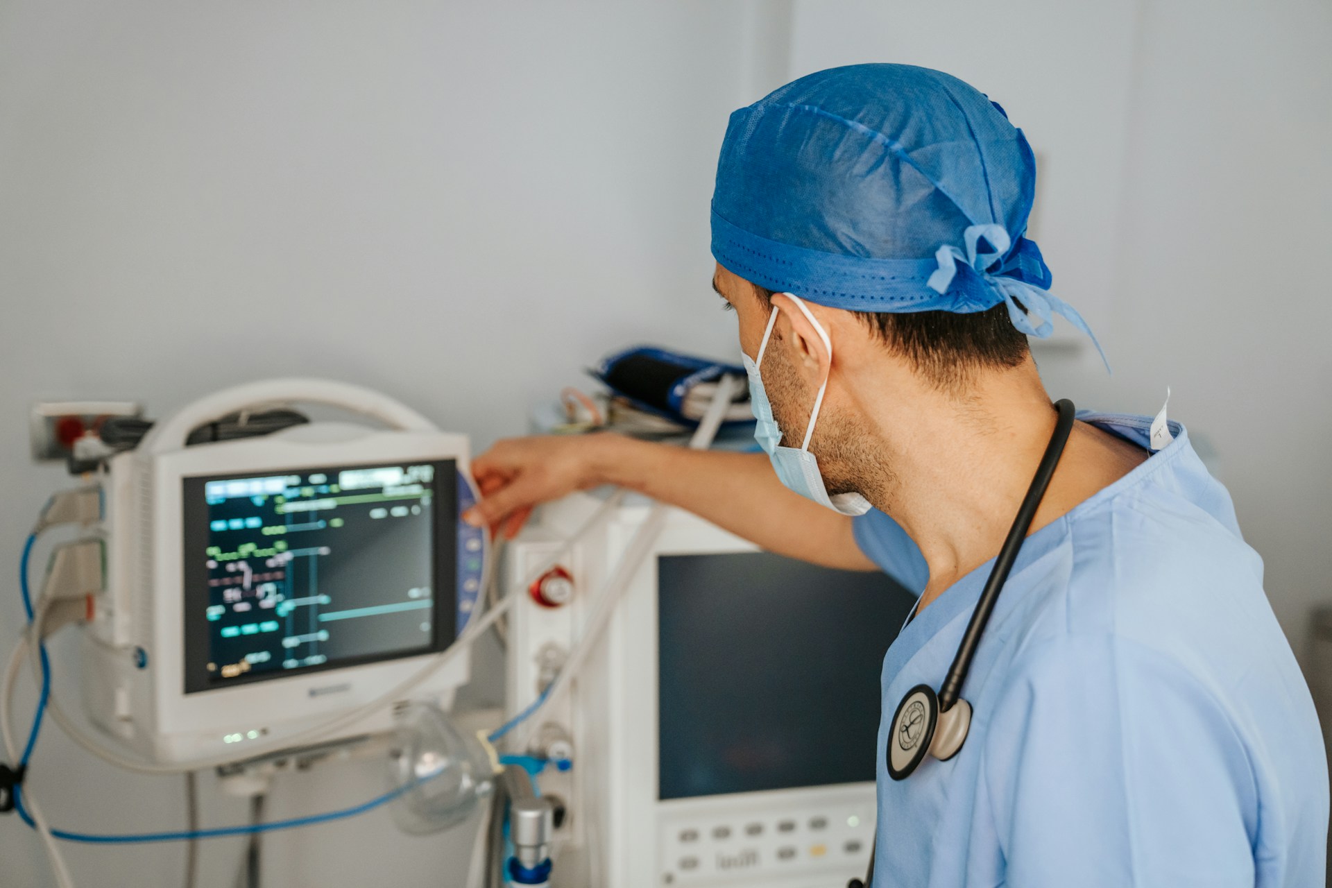 man in scrubs looking at monitor