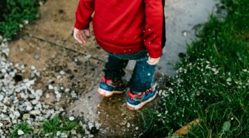 kid jumping in puddle
