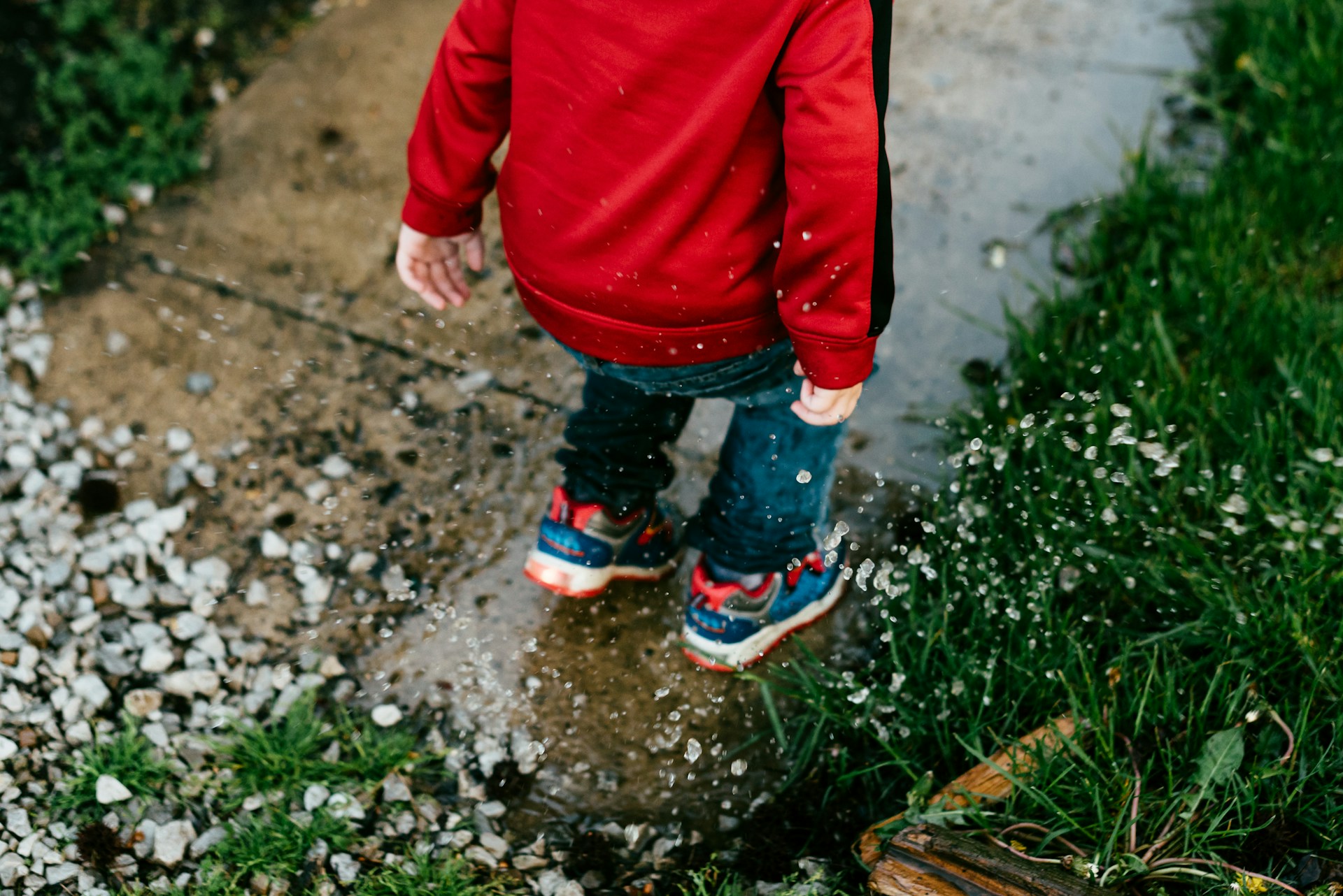 kid jumping in puddle